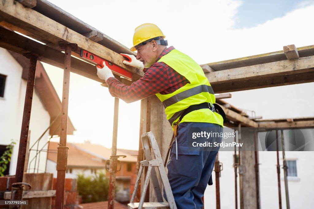 Senior Caucasian Construction Worker Using Level Tool While Working On ...