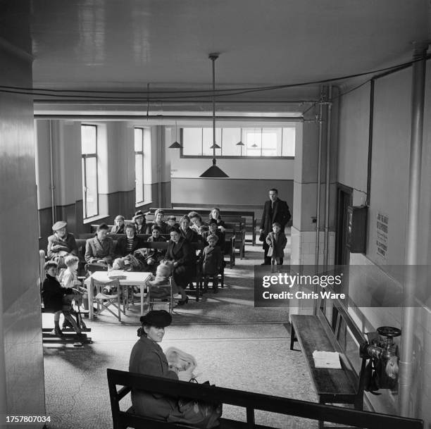 People in the waiting room of the children's clinic at Guy's Hospital in Southwark, London, England, February 1948.