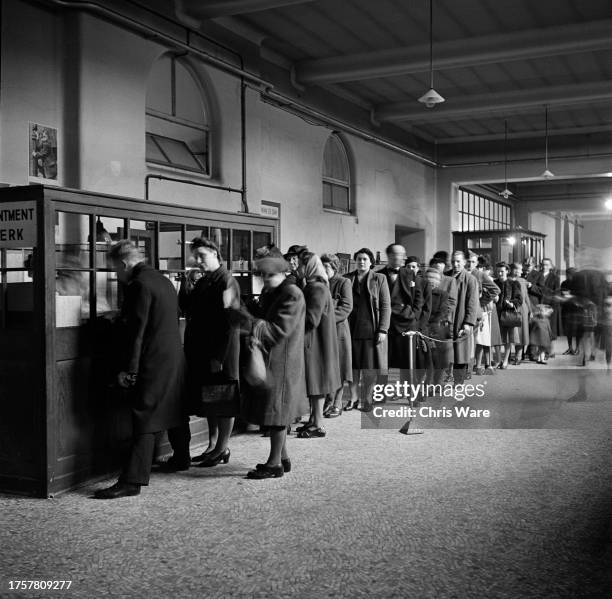 Queue of people await their turn at the office of the Main Outpatients Hall of Guy's Hospital in Southwark, London, England, February 1948.