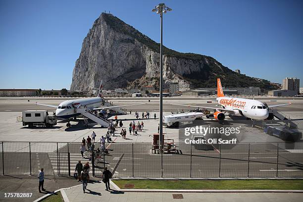 Passengers disembark a flight shortly after landing at Gibraltar International Airport on August 8, 2013 in Gibraltar. David Cameron has spoken with...