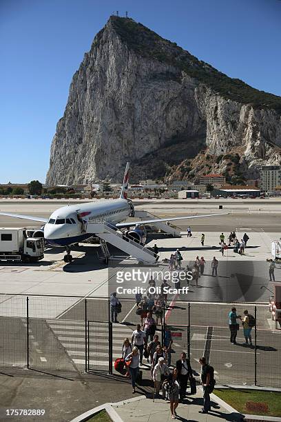 Passengers disembark a flight shortly after landing at Gibraltar International Airport on August 8, 2013 in Gibraltar. David Cameron has spoken with...