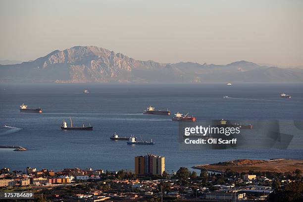 Large industrial ships wait in the Straight of Gibraltar adjacent to the Rock of Gibraltar, with Moroccan mountains on the skyline, on August 7, 2013...