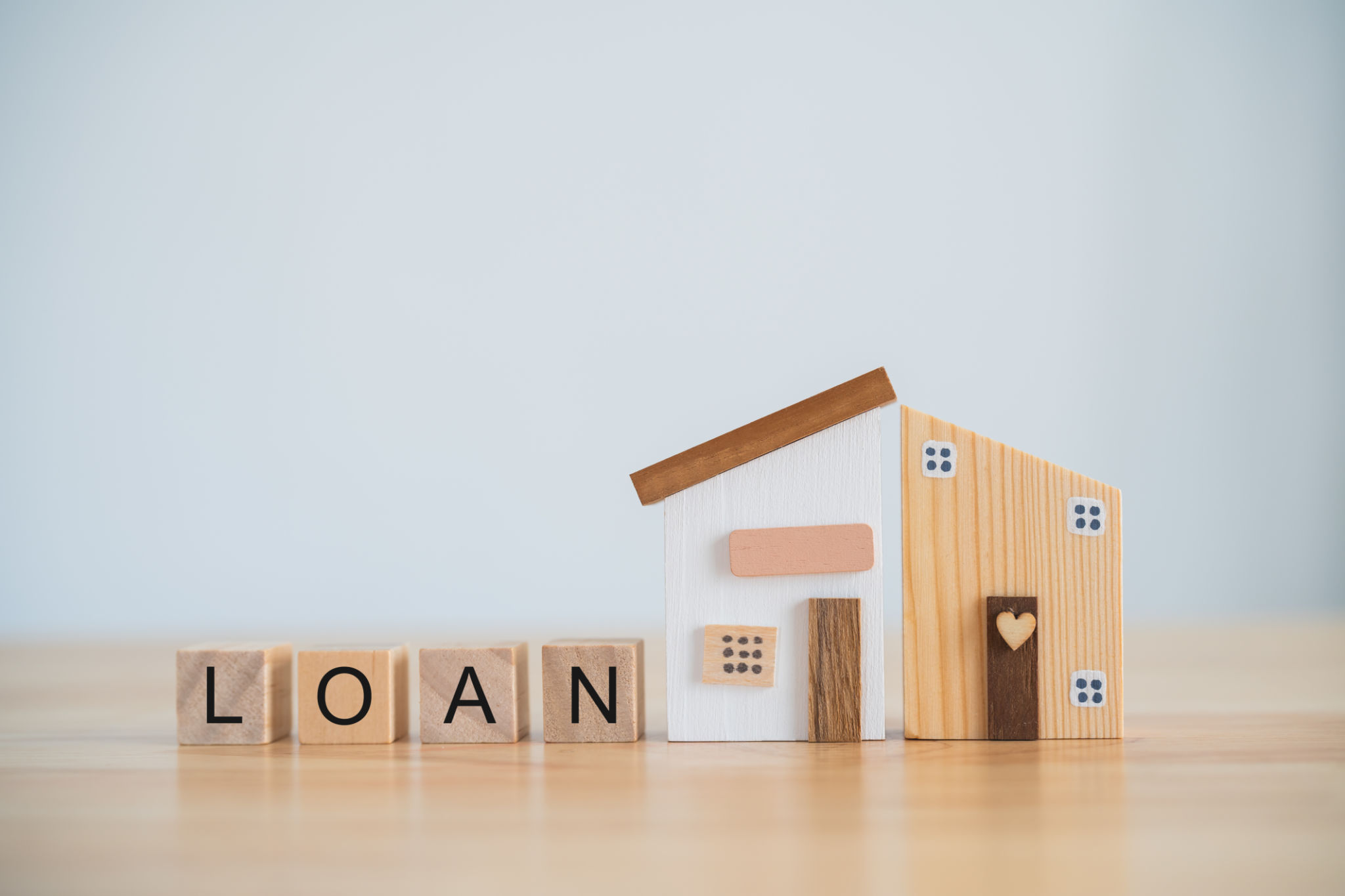 Model house and wood blocks with word LOAN on table. plan finances investments and savings to buy house real estate.Money coin and home on table business accounting and tax and insurance concept. Model house and wood blocks with word LOAN on table. plan finances investments and savings to buy house real estate.Money coin and home on table business accounting and tax and insurance concept.