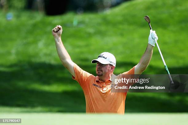 Robert Garrigus of the United States celebrates chipping in for birdie on the ninth hole during the first round of the 95th PGA Championship on...