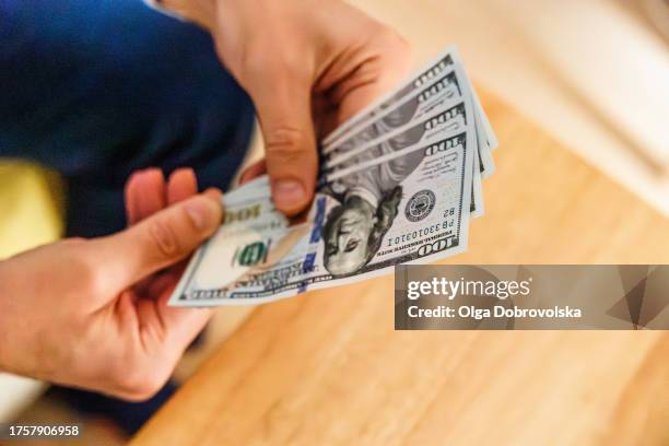 a person holding american dollar banknotes in his hands - deposits and loans fund stock pictures, royalty-free photos & images