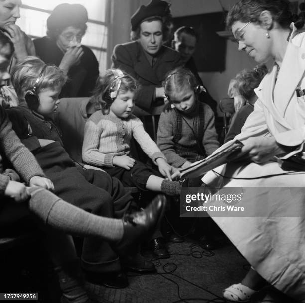 Speech therapist Sylvia Martin teaching hearing impaired children to articulate the words 'long socks' and 'short socks' during a group lesson at a...