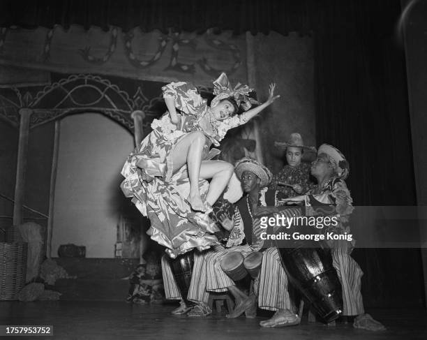 Choreographer and dancer Katherine Dunham leaping in the air during a performance of 'A Caribbean Rhapsody' at the Prince of Wales Theatre in London,...