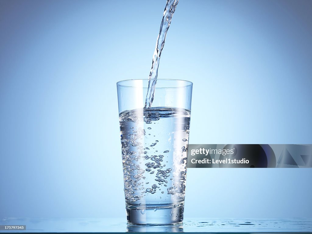 Cold drink water being poured into glass