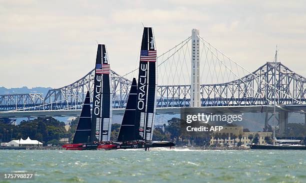 Oracle Team USA sails its AC72 catamarans past the Bay Bridge's new east span while training for September's America's Cup on August 6 in San...