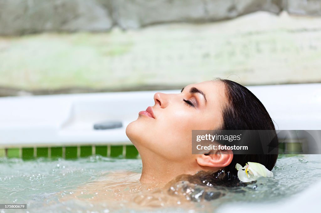 Beautiful woman relaxing in hot tub at health spa