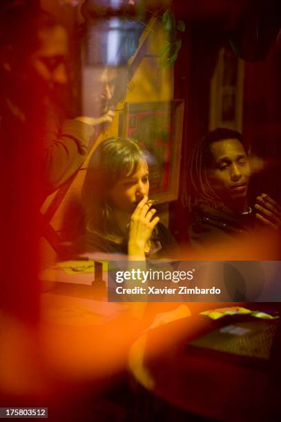 Young people smoking and looking at a computer in a bar at night on January 20, 2005 in Sarcelles, a Paris suburb, France