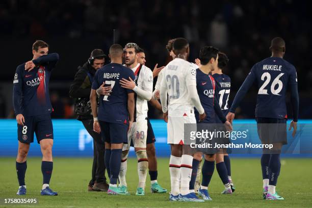 Theo Hernandez of AC Milan emrbaces Kylian Mbappe of PSG as players from both teams salute each other following the final whistle of the UEFA...