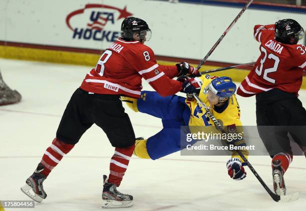 Anthony Mantha of Team Canada checks Andre Burakowsky of Team Sweden during the 2013 USA Hockey Junior Evaluation Camp at the Lake Placid Olympic...