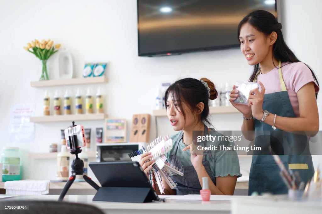 Propietarios de pequeñas empresas, vlogger o bloguera de belleza profesional asiática, transmitiendo en vivo un videoclip viral tutorial de maquillaje cosmético a través de una videollamada, compartiéndolo en las redes sociales.