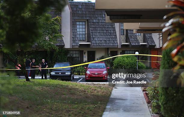 Police stand near the orange door which is the front door to a townhouse where seemingly a husband reportedly confessed on Facebook to murdering his...