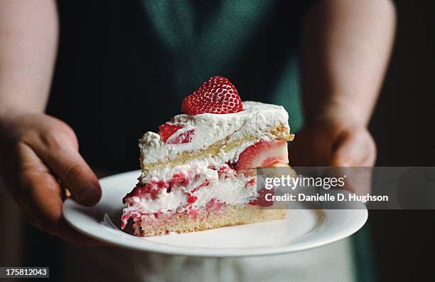 woman in apron holding slice of strawberry cake - pastel fotografías e imágenes de stock