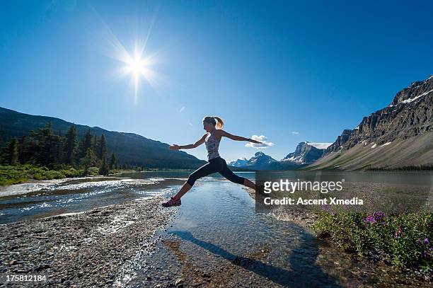 teenage runner jumps across creek, mountain lake - leap forward stock pictures, royalty-free photos & images