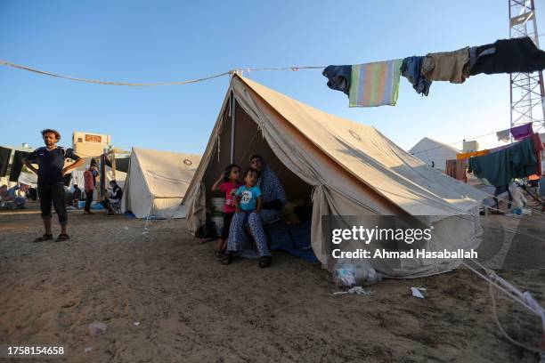 Children sit in a tent at a refugee camp set up for Palestinians seeking refuge along the Gaza Strip on October 26, 2023 in Khan Yunis, Gaza. Heading...