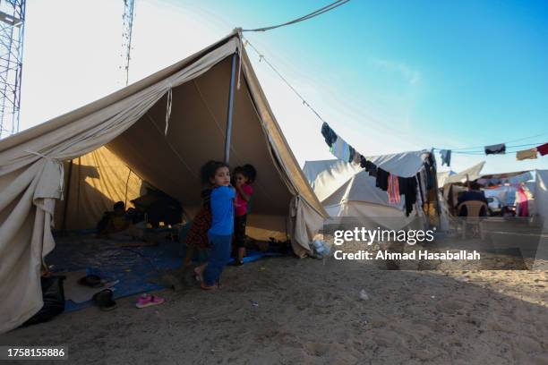 Children sit in a tent at a refugee camp set up for Palestinians seeking refuge along the Gaza Strip on October 26, 2023 in Khan Yunis, Gaza. Heading...