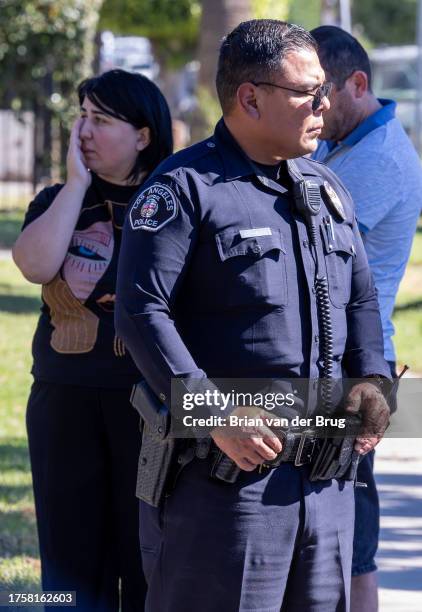 Van Nuys, CA Los Angeles Unified School District police officer stands guard with concerned staff and parents during a campus lockdown following a...