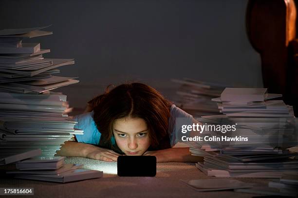 girl lying on front watching cell smartphone surrounded by books - surrounding stock pictures, royalty-free photos & images