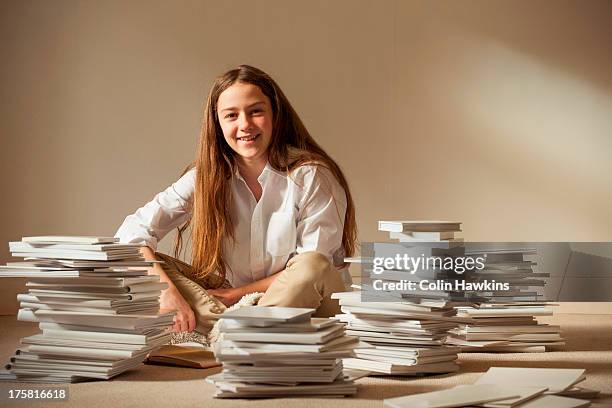 girl sitting on floor surrounded by piles of books - surrounding stock pictures, royalty-free photos & images