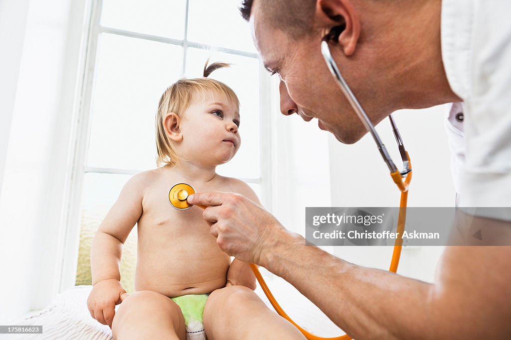 Doctor examining toddler girl with stethoscope