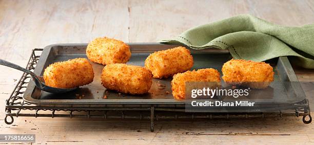 potato croquettes on baking sheet on wire rack - pommes de terre cuisinées photos et images de collection