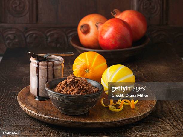 ingredients for dry cured pork loin. brown sugar, molasses, pomegranates and orange and lemon rind - brown sugar stock pictures, royalty-free photos & images