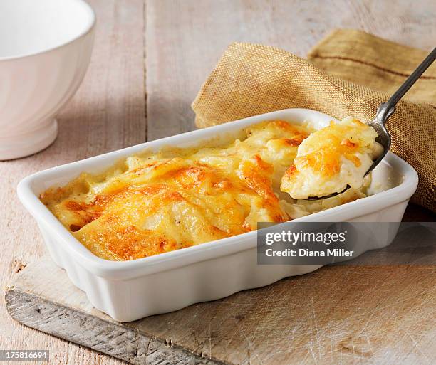 potato gratin in white serving dish with metal spoon - 洋食 ストックフォトと画像