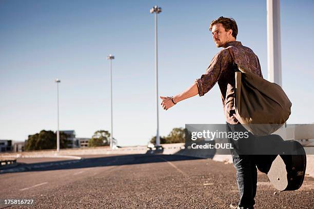 young man hitch hiking - hitchhike stock-fotos und bilder