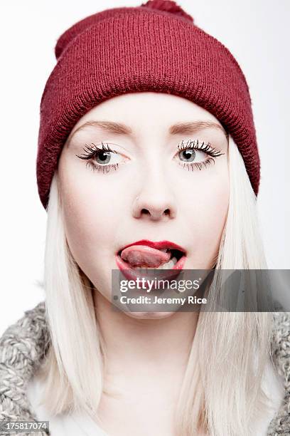 young woman wearing red hat licking lips - licking lips stock pictures, royalty-free photos & images