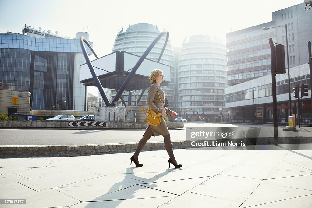 Businesswoman walking in Old Street, London, England, UK