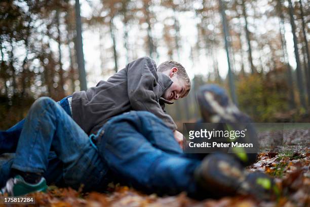 boys play fighting on forest floor - 玩耍式打鬧 個照片及圖片檔