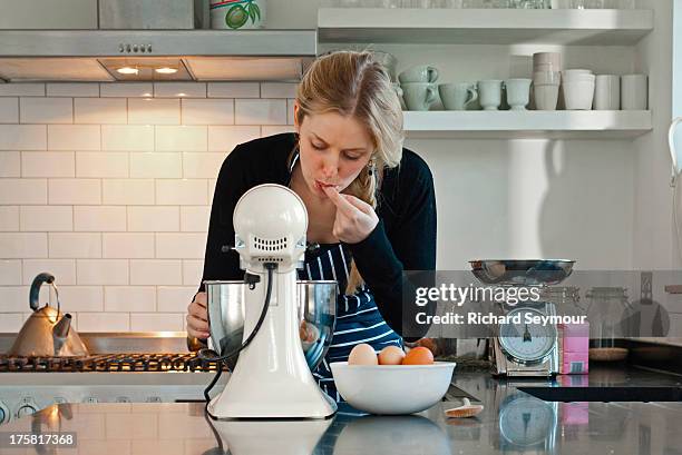 woman tasting dough mix - electric whisk stock pictures, royalty-free photos & images