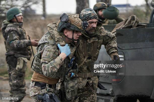 Ukrainian military man is helped at the evacuation point on November 1, 2023 in Kupiansk, Ukraine. Military medics provide first aid and evacuate...