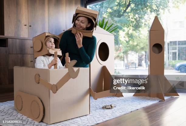 family as mother, son and daughter playing role play game as as astronauts on mars. - carton stock pictures, royalty-free photos & images