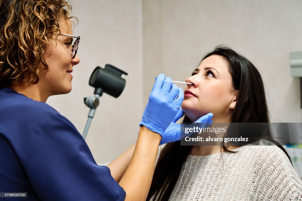 Doctor using swab while doing a test to a patient