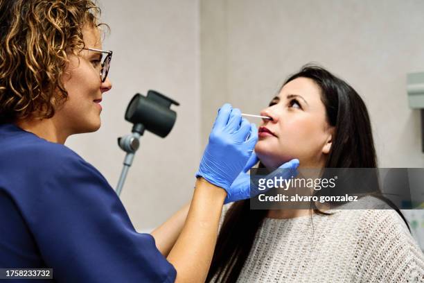 doctor using swab while doing a test to a patient - nasal swab stock pictures, royalty-free photos & images