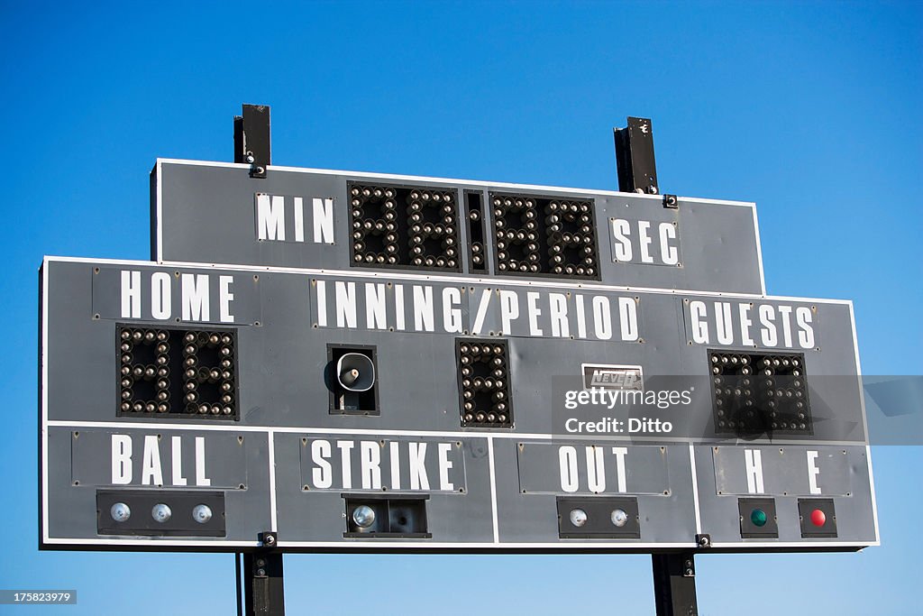 Baseball scoreboard against blue sky