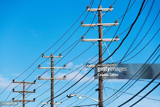 cables attached to telegraph pole against blue sky - telefonleitung stock-fotos und bilder
