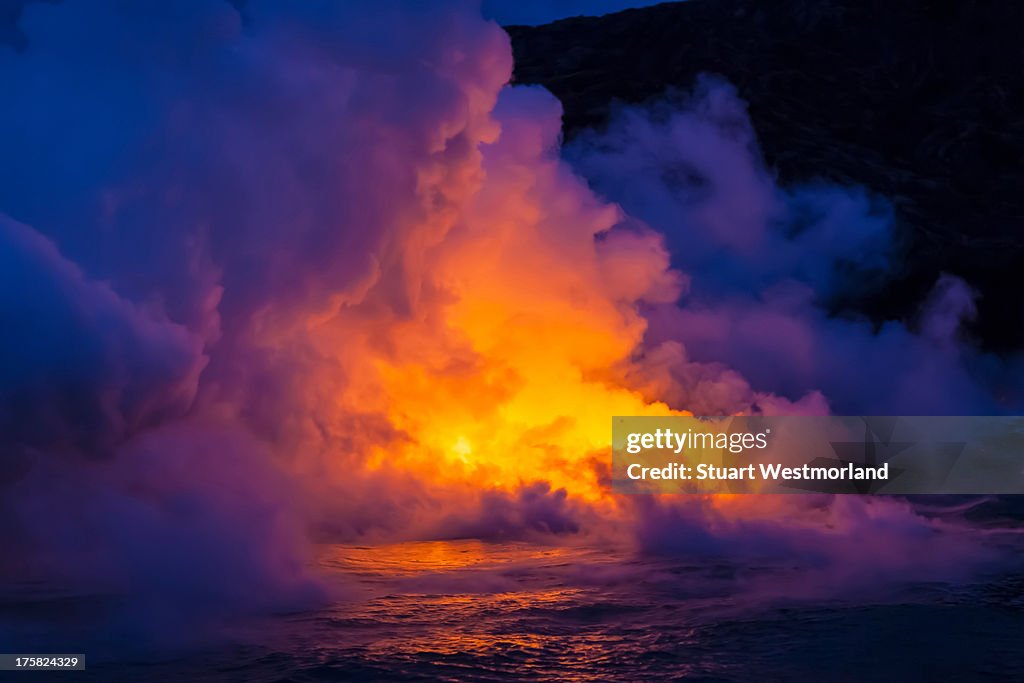 Smoke clouds from lava flow impacting sea at dusk, Kilauea volcano, Hawaii