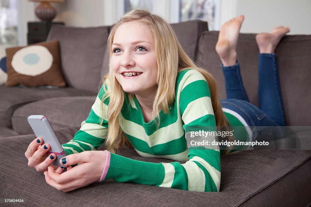 Girl lying on front using smartphone