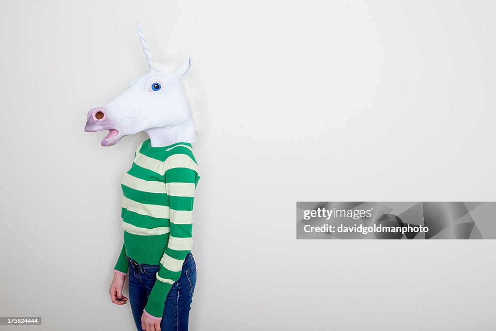 Girl wearing unicorn head