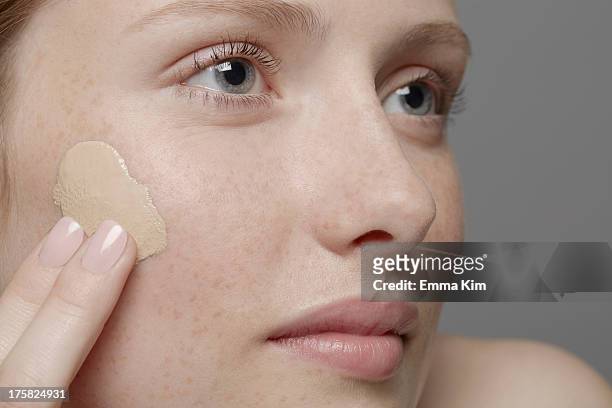 close up of part of young woman's face, applying concealer - concealer stock pictures, royalty-free photos & images
