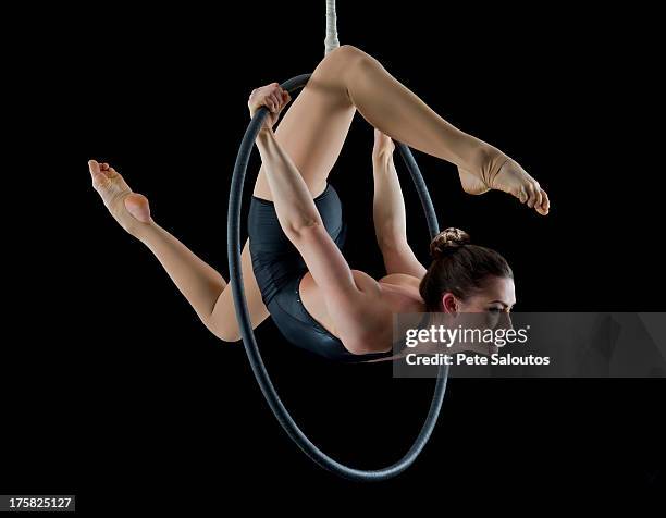 aerialist performing on hoop in front of black background - great effort stock pictures, royalty-free photos & images