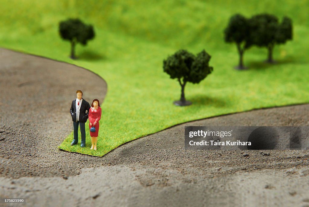 Figurines on pretend grass with trees