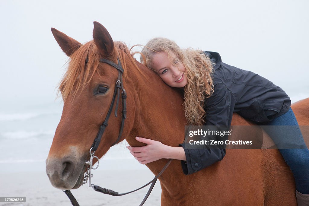 Woman riding horse on beach