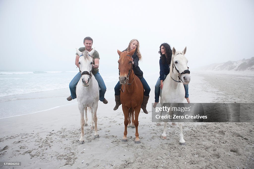 People riding horse on beach