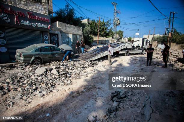 Palestinians inspect the damage of the buildings and streets following an Israeli military raid in a Jenin refugee camp in the occupied northern West...